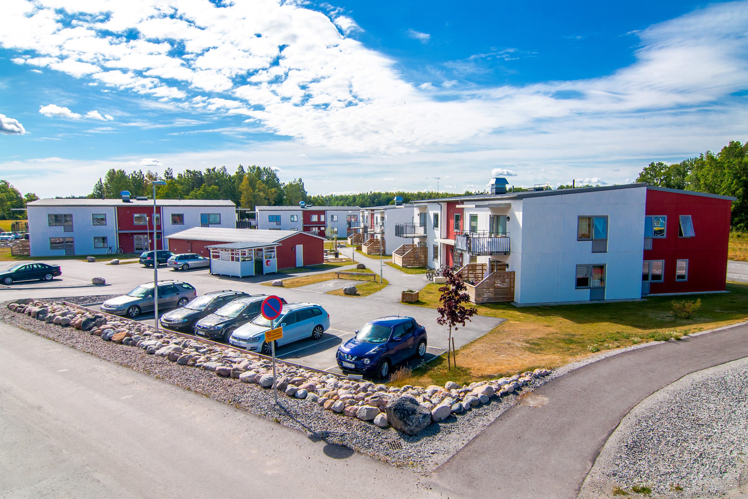 Bostadosmråde med tvåvåningshus och parkering framför