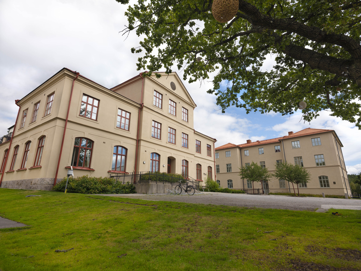 Äldre skolbyggnad med putsad, ljus fasad