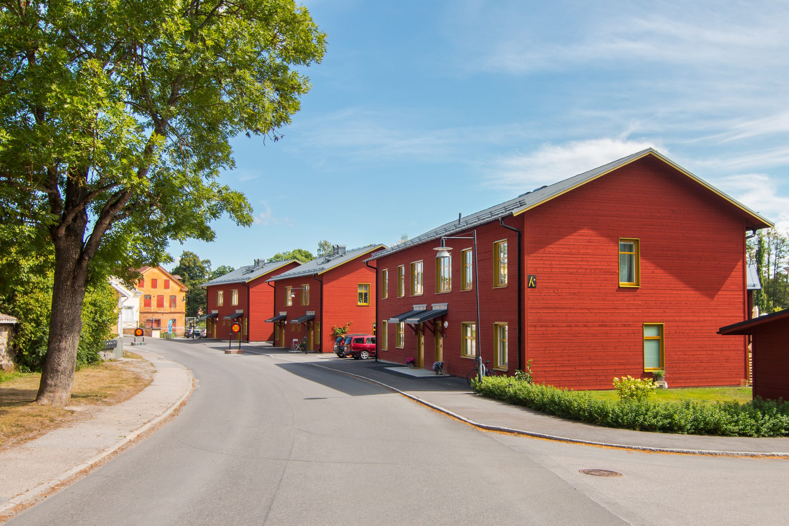 Röda trähus längs gata.