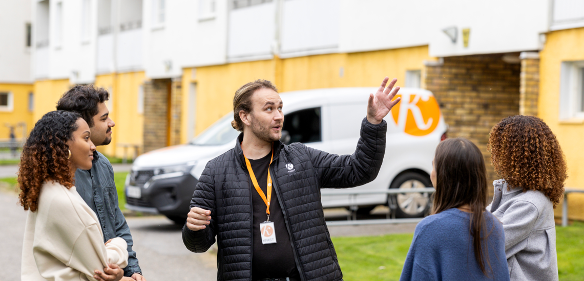 Kfast-medarbetare pratar med fyra hyresgäster i bostadsområde.