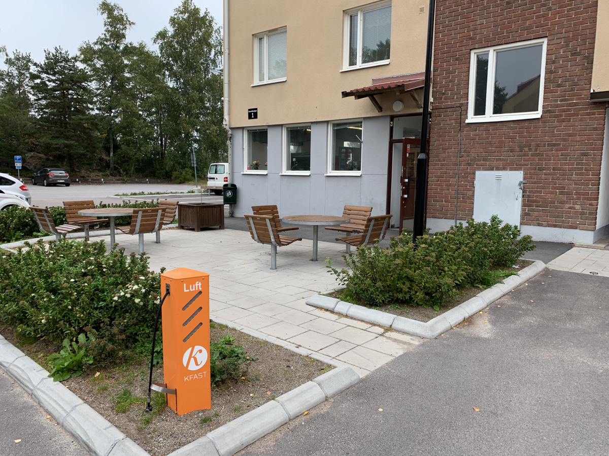 Orange cykelpump märkt Kfast framför fastighet