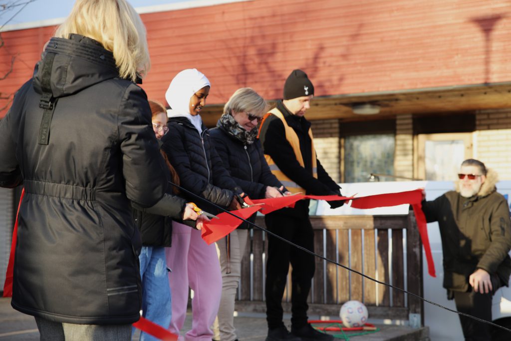 Några personer som klipper ett rött band.